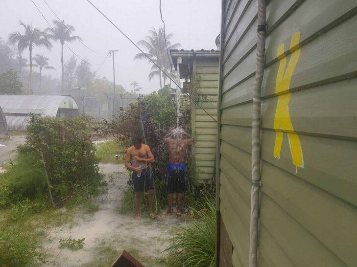 Men inside the now-closed regional processing centre at Manus Island, purportedly showering in the rain.