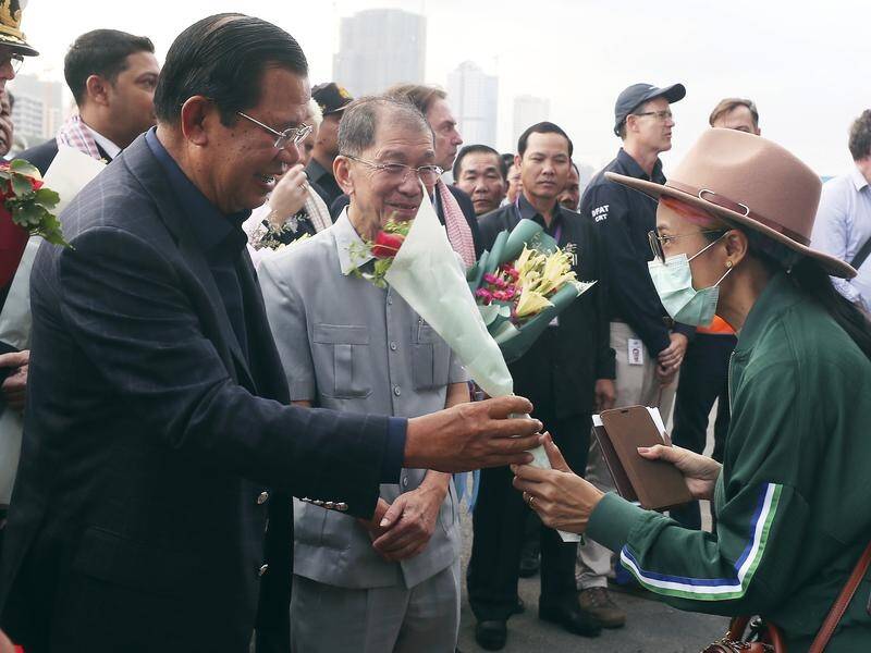 Cambodia's Prime Minister Hun Sen gives flowers to a passenger from the cruise liner Westerdam.
