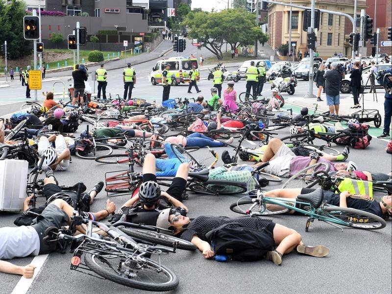 About 40 cyclists have staged a "die in" on a Brisbane road to call for a network of bike lanes.