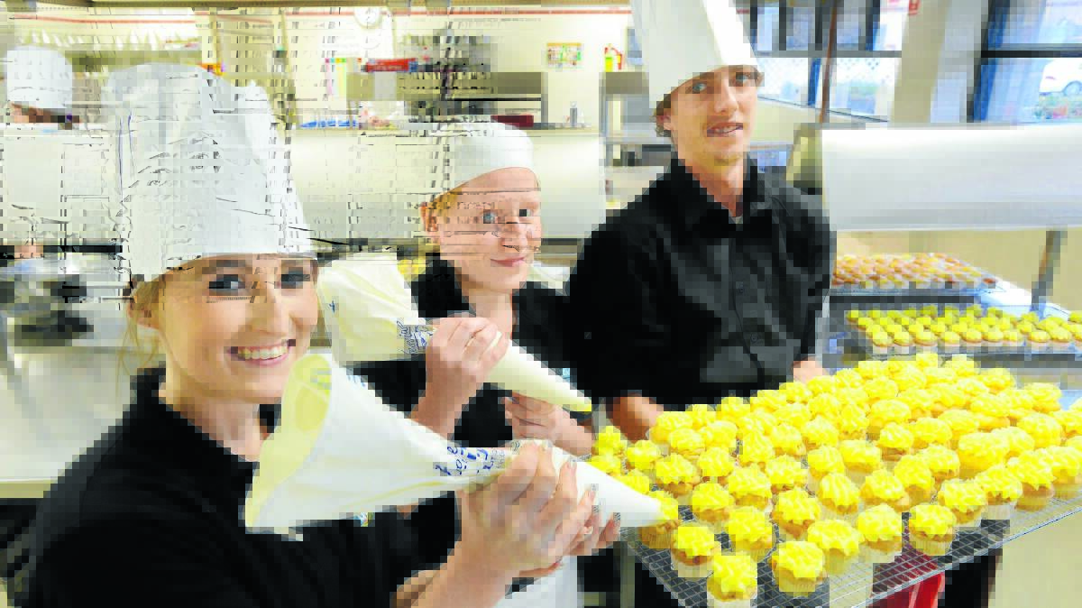TASTY TREATS: Hospitality students Eliza Stevenson, Dylan Ramsey and Georgia Hartley with their tasty creations for Daffodil Day. Photo: Barry Smith 210814BSC02