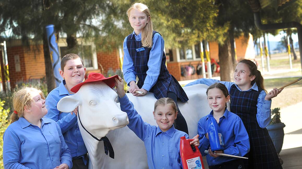 HOW NOW WHITE COW: Westdale student Tarnee Witton sits on Westdale’s Picasso cow while fellow Year 6 students Rashinda McKee, Brendan Daniels, Ebonie Abra, Jasmine Wernhard and Madilyn Chenoweth get ready to paint. 
Photo: Gareth Gardner 120814GGD02