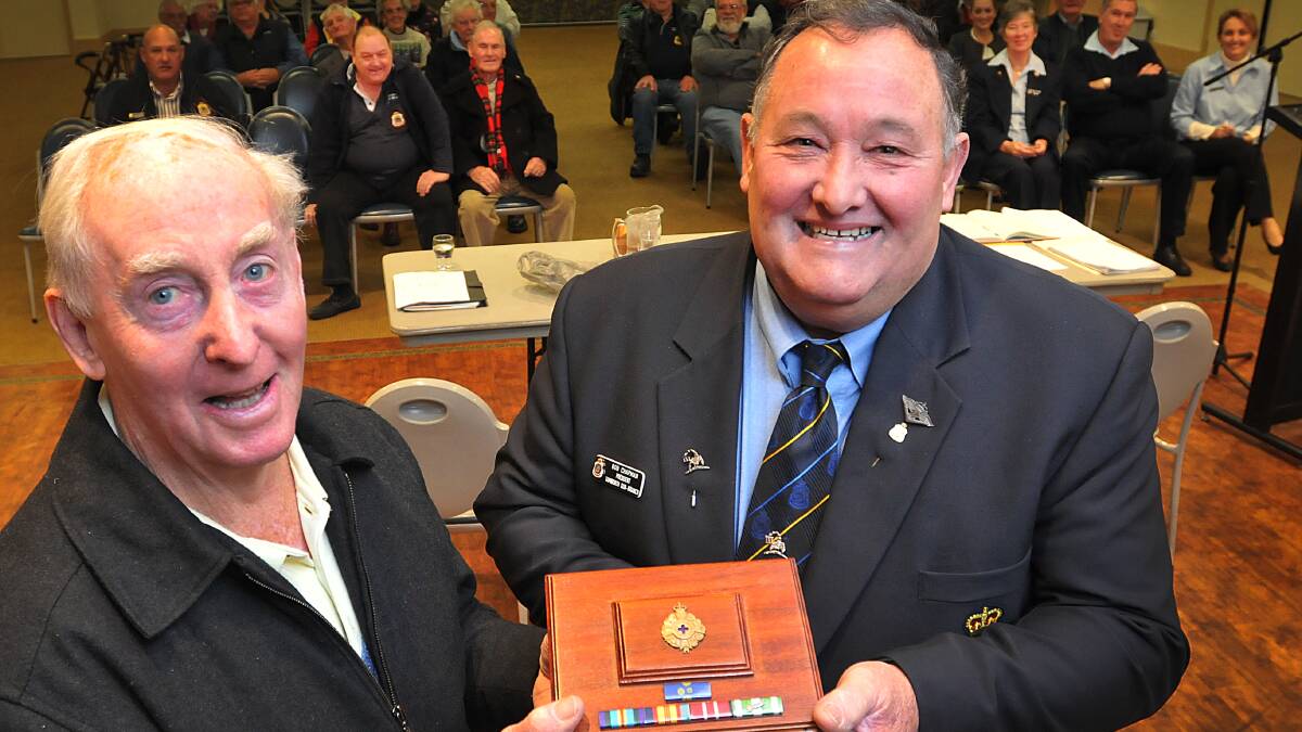 OVERWHELMING GIFT: Tamworth RSL chaplain Father Tom Shanahan gets the special handmade wooden box from sub-branch president Bob Chapman. Photo: Geoff O’Neill 290614GOA01