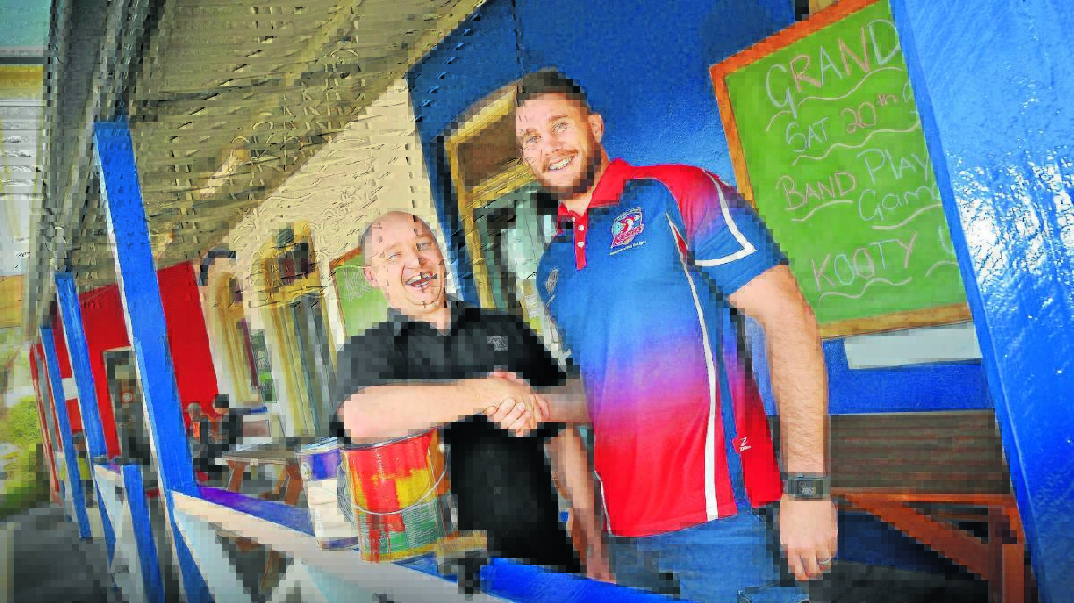 JOB WELL DONE: Kootingal Roosters captain-coach Nathan Hamlin, right, congratulates Kootingal Hotel owner Andrew Yeo on his new pub paint job. Mr Yeo painted the historic pub in Roosters colours as part of a bet on whether the team would make the Group 4 grand final. Photo: Gareth Gardner 1509GGB01