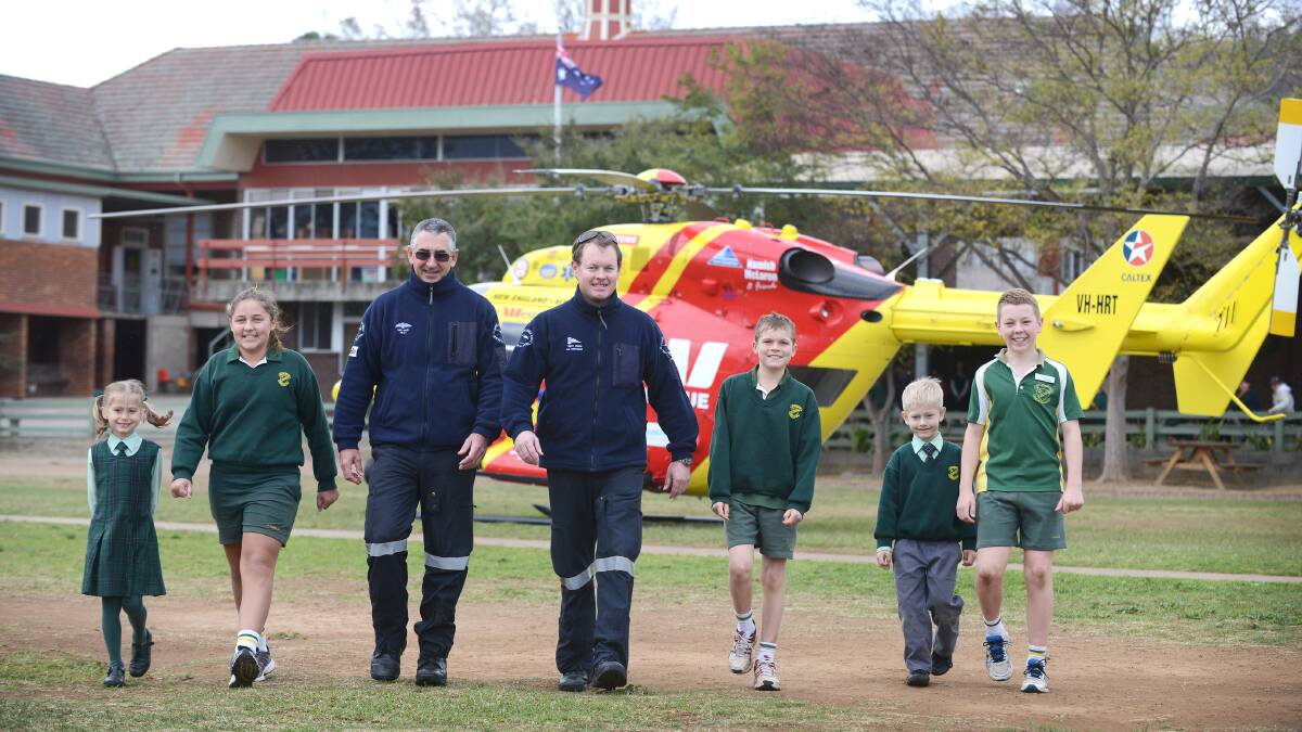 TOP GUN: Greeting the Westpac helicopter on the St Nicholas Primary School oval are Audrey Lloyd, Olivia Sellers, pilot Dave Davies, senior air crewman Trent Owen, Jordan Butler, Lachlan French and Dominic Haire. Photo: Barry Smith 200614BSB08