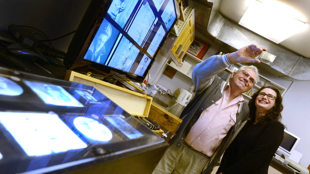 HISTORY IN THE MAKING: Tamworth Film and Sound Archive president Ian Austin and volunteer Miranda Heckenberg look through the glass cinema slides from World War I that will form part of a new documentary. Photo: Barry Smith 230914BSC04