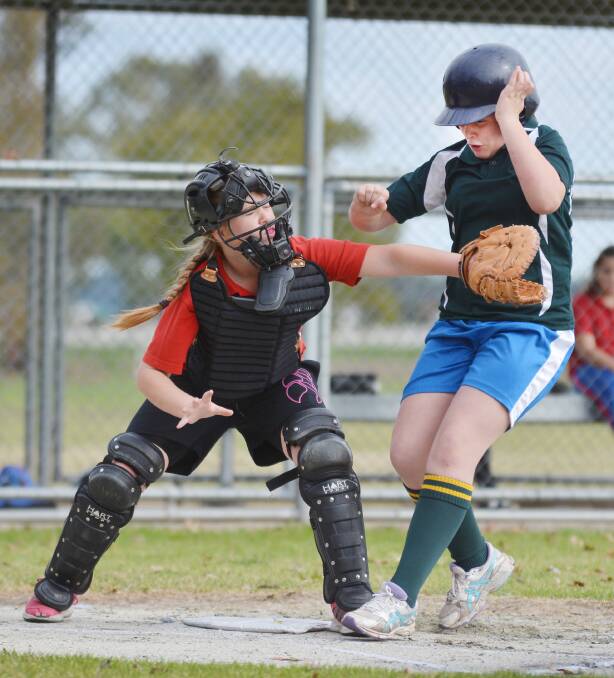 Narrabri West catcher Zara Foley making an out against Katelyn Isaac in yesterday’s Regional PSSA Softball Final. Photo: Barry Smith  230615BSA32