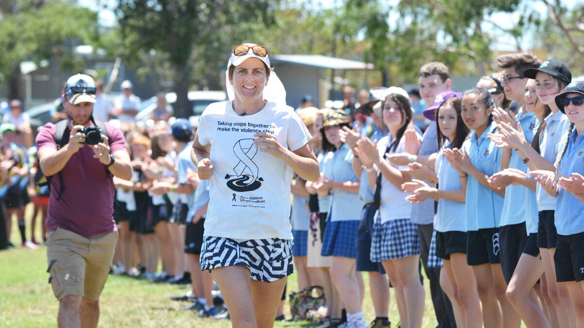 RUNNING FOR CHANGE: Ultra-marathon runner Kirrily Dear runs through a guard of honour ahead of the annual White Ribbon Cup rugby league match between Tamworth and Peel High schools and Parry School. Photo: Barry Smith 181114BSD06