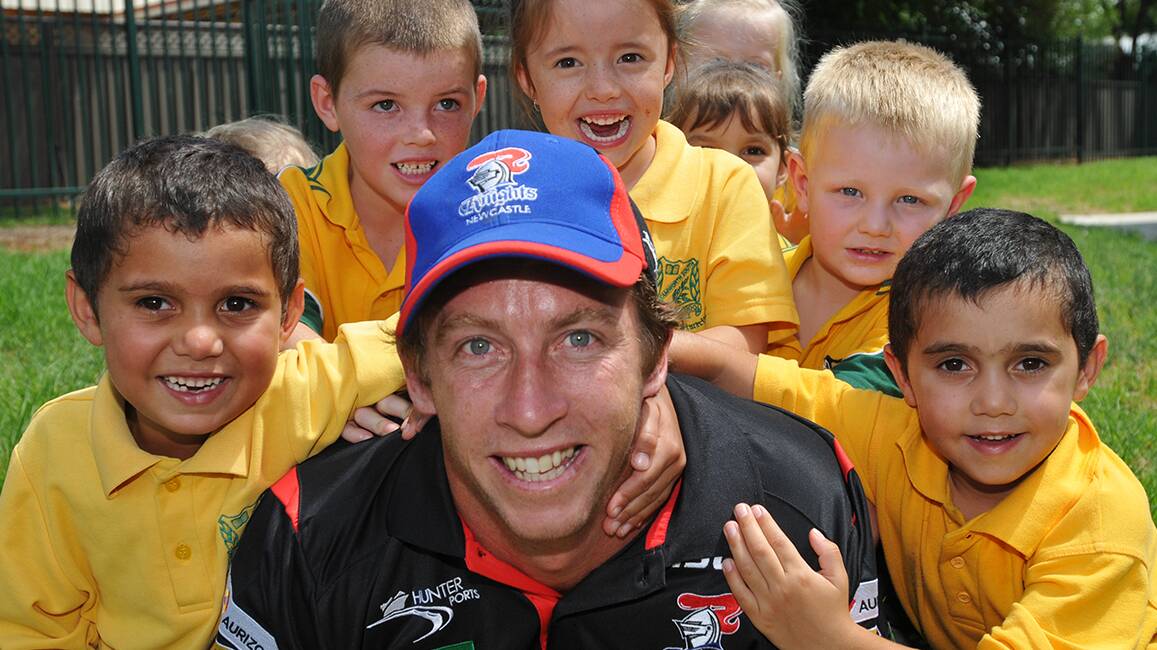 SHINING ARMOR: Newcastle Knights captain Kurt Gidley is swamped by pint-sized fans – Callum Doolan, left, Mason McDonald, Kaleisha Cullen, Will Vernon and Tristan Doolan – during a visit to Tamworth South Public School 
yesterday. Photo: Geoff O’Neill 210214GOE03