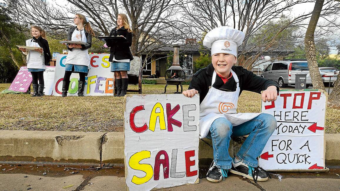 ICING ON THE CAKE: ‘Masterchef’ Darcy McDonald whipped up some baked goods to sell with his sisters Nikita, 8, Kimberley, 15, and Karlia, 14. Photo: Barry Smith 100714BSD03
