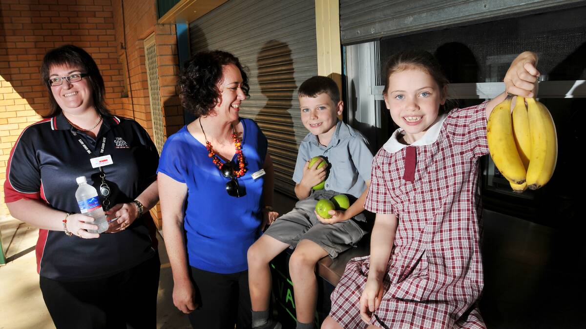 GETTING FRUITY: Oxley Vale Public School pupils Bradley Cruickshank, 7, and Emma Worland, 7, with Kathy Webb from The Good Guys Tamworth and Year 1 teacher Helen Rowsell in preparation for next month’s Jamie Oliver Food Revolution Day. Photo: Gareth Gardner 290414GGB01
