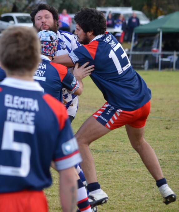 Kaidyn Saunders (13) played a big role defending and attacking down the left side in 
Kootingal’s win over premiers Barraba. Here he helps Lad Jones (headgear) stop Bulldogs captain-coach Tim Coombes with Jordan Fisher  looking on.  Photo: Christopher Bath 140614CBA35