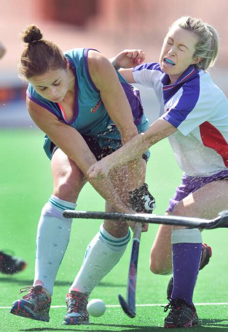 Waratahs’ Jess Thomas (right) loses her grip during this contest with Flames’ Mel Allen.  Photo: Gareth Gardner 240814GGD03