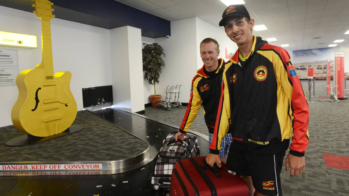 Jobe Bottrell (back) and Zarayn Knight grab their bags after returning from the Oceania Cup Oztag in New Zealand.  Photo: Gareth Gardner  310314GGE01