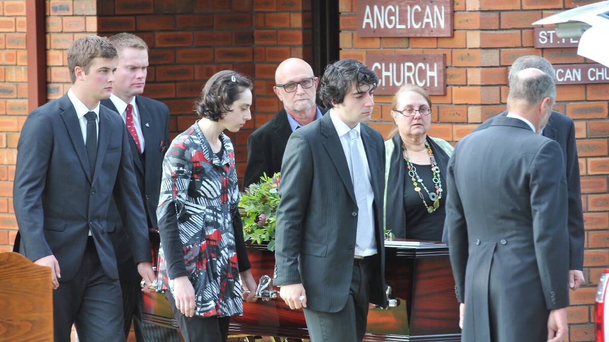 GONE TOO SOON: Dr Martin Pearson’s family, including his wife, Sandy, children Elizabeth and James and brother Dr John Pearson (obscured), carry his coffin from the church. Photo: Gareth Gardner  060514GGC01
