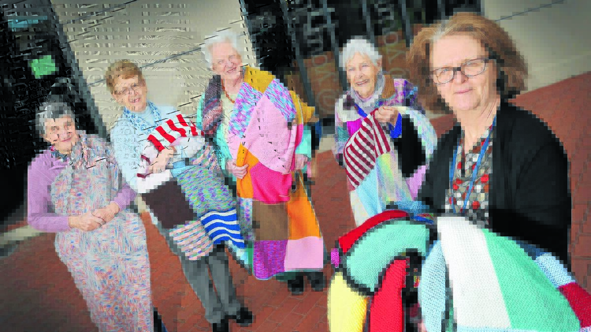 NATTY KNITTERS: Tamworth Library Knitters Group members Ann Foster, Beryl Gordon, Dorothy Randall, Chris Smith and Megan Pitt show off rugs to be donated to the Wrap with Love project. Photo: Gareth Gardner 180714GGB01