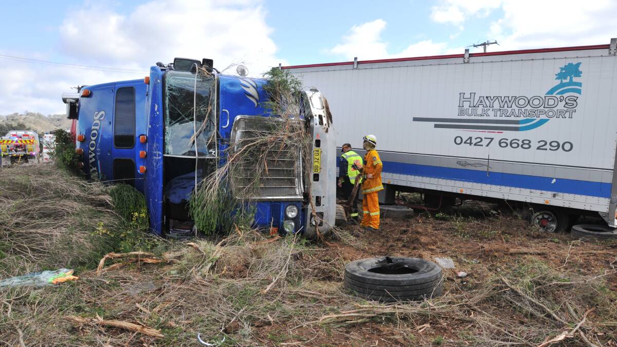 WHAT A MESS: Emergency services survey the wreckage of the b-double after it rolled off the New England Highway near Tamworth yesterday morning. Photo: Geoff O'Neill 160614GOB02