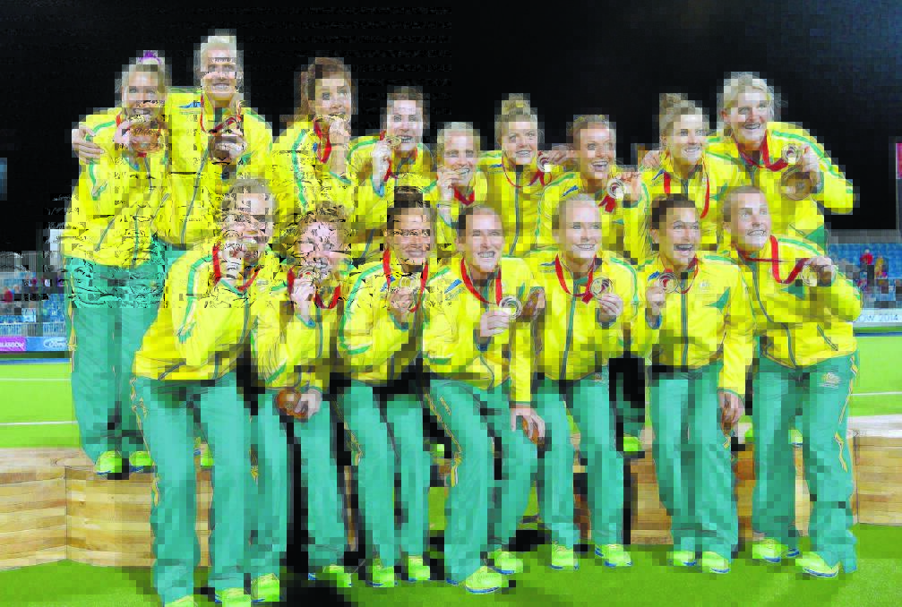 GOLDEN MOMENT: Kate Jenner (back second from right) and her Hockeyroos team-mates show off their Commonwealth Games gold medals following their dramatic win over England. Photo: Ady Kerry – Ak Pictures