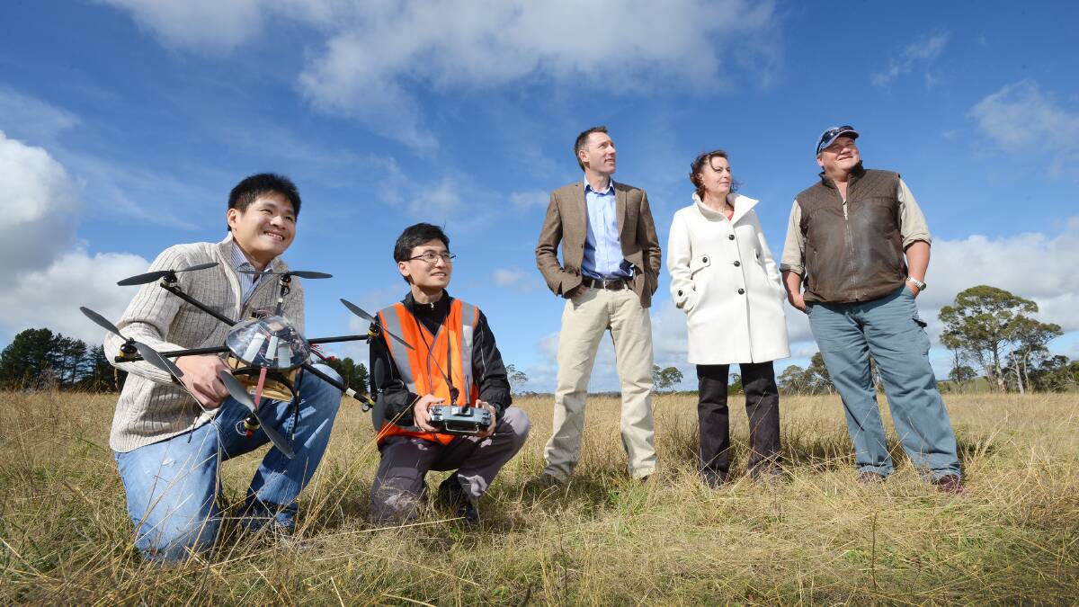 EXCITING NEW TOOL: Calvin Hung, left, and Zhe Xu from Sydney University’s Australian Centre for Field Robotic Research with Scott Charlton (NSW DPI), Maria Woods (chair Northern Inland Weeds Advisory Committee) and Mike Whitney (Liverpool Plains Shire Council weed officer) in the Dangarsleigh area near Armidale showing off a drone following a 12-month trial. Photo: Barry Smith 100614BSA17