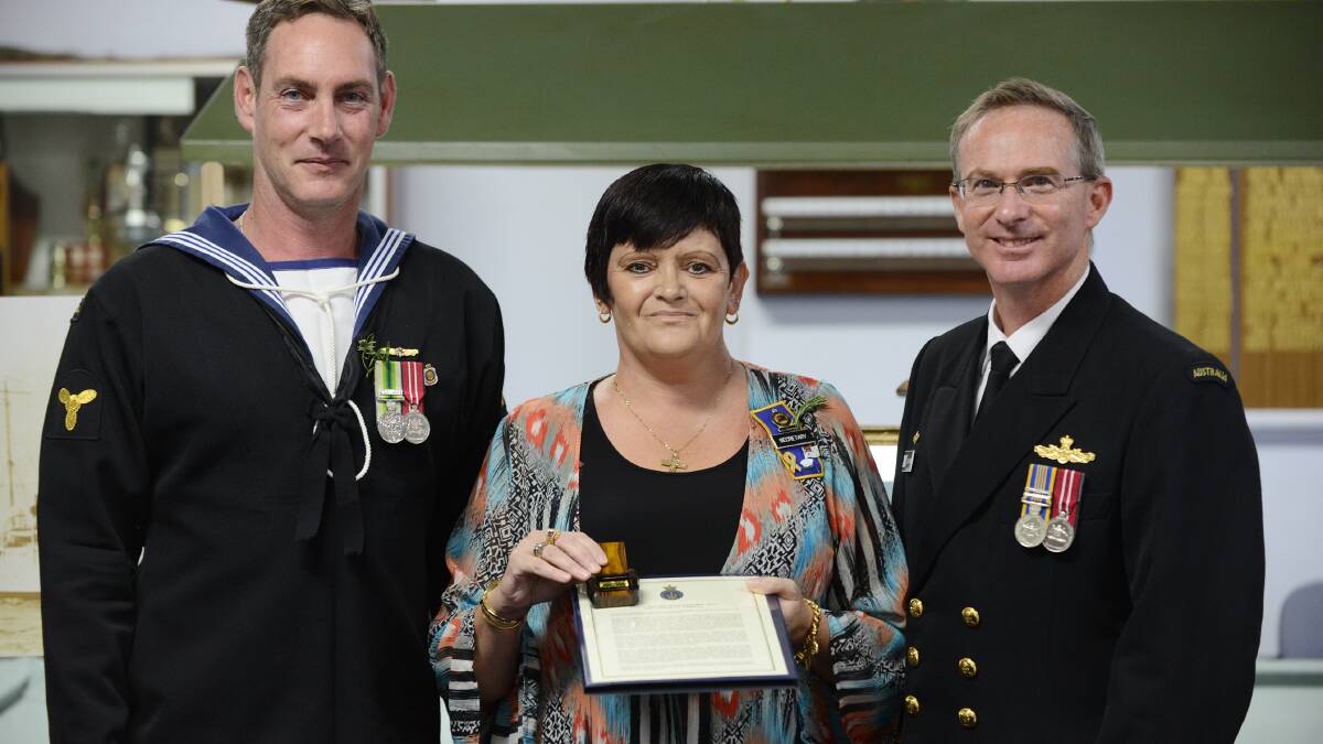 FAMILY TIES: From left, Leading Seaman (Ret) and Manilla RSL Sub-branch vice-president Duncan Ellem, Janene Avery and navy Captain Jason Sears with the unit citation. Photo: Barry Smith 250414BSF12