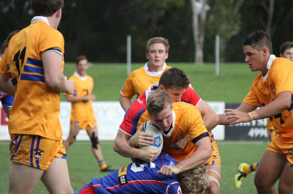 Hayden Loughrey on the attack for the GNA Tigers in last Saturday’s trial against Newcastle Knights at Cessnock’s Baddeley Park. Teammates Blake Kellett (11 left) Cameron Howard (back) and Jack Jeffrey (right) lend a hand. Photo:  Scott Bone