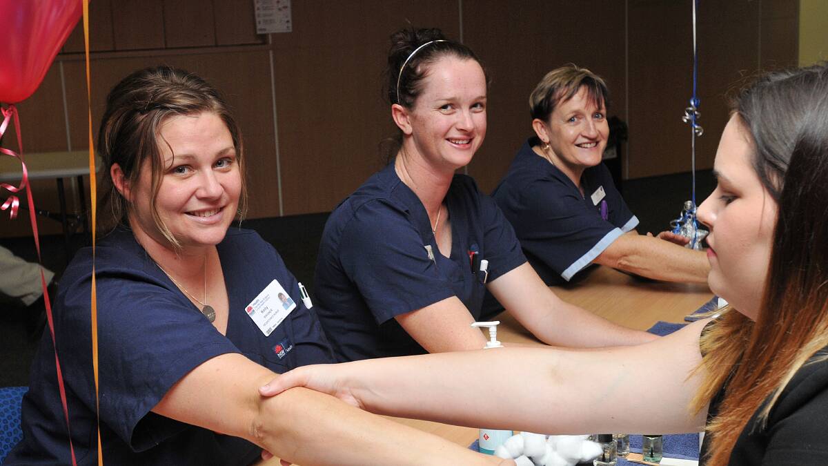 PAMPERED: Enjoying a massage from TAFE students on Monday were, from left, Kelly Wagner, Liz Chamberlain and Karen Humphrys. TAFE student Katie Nelson is pictured right. Photo: Geoff O’Neill 120514GOF01