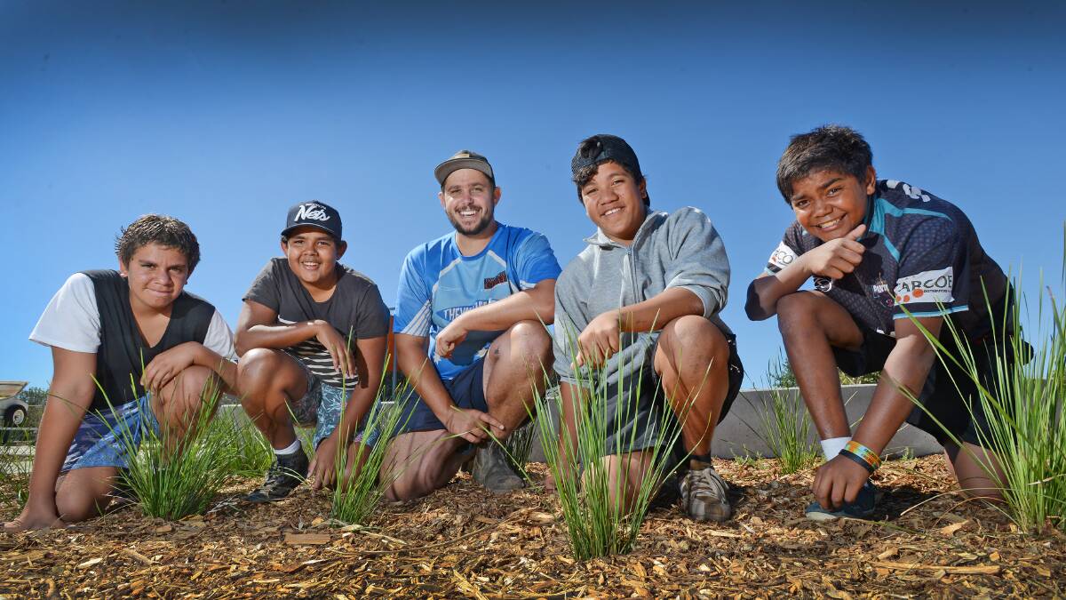 GOOD THINGS GROW: Tamworth Regional Council’s youth services assistant Marc Sutherland (centre) and his band of volunteers, from left, Kein Knox, 14, Tevita Tavo, 13, Maene Trindall, 13, and Makalyn Brown, 14, survey their handiwork. Photo: Barry Smith 090415BSA01