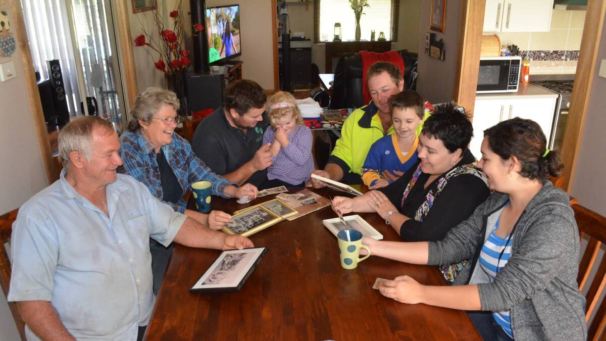Looking over 100 years of history is third generation dairy farmer Ian Alley with his wife Leanne, son Clayton who sits with his daughter Charlotte, older brother Anthony who is with his son Lachlan, wife Leanne and daughter Gabby. Photo: DANIELLE BUCKLEY
