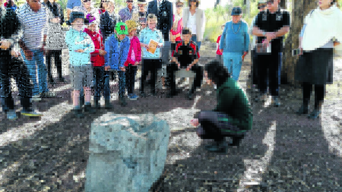 PASSING IT ON: During last year’s commemorations, Macintyre High School student Emma Kneipp read to visitors from a plaque, with Inverell High Clontarf Academy student Troy Neilson sitting behind her. Photo: Brett Newton