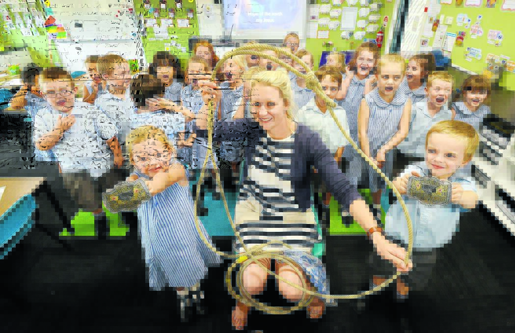 ROPED IN: St Edwards’ teacher Sallie Pilgram does a cowgirl show and tell with Hannah Kapeller, Jett Lewis and her KP kindergarten class. Photo: Barry Smith 150316BSC04