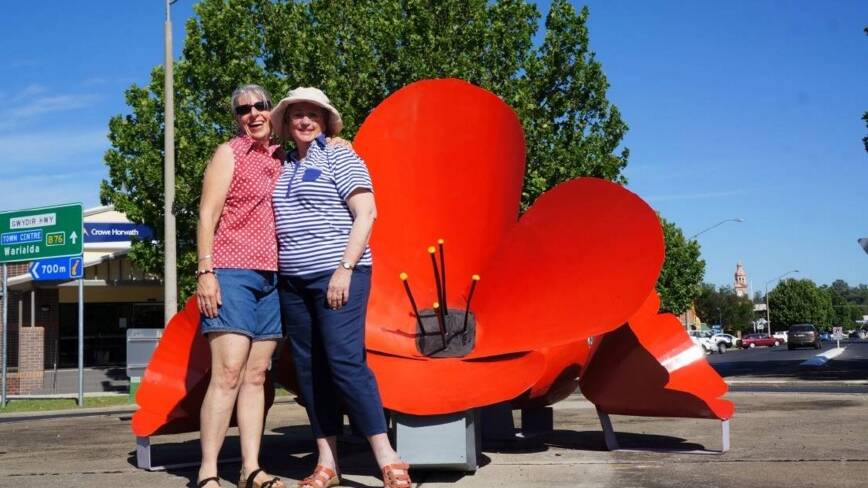Kurrajong Re-enactment committee president Kim Blomfield with Ann Hodgens following the installation of the giant poppies.