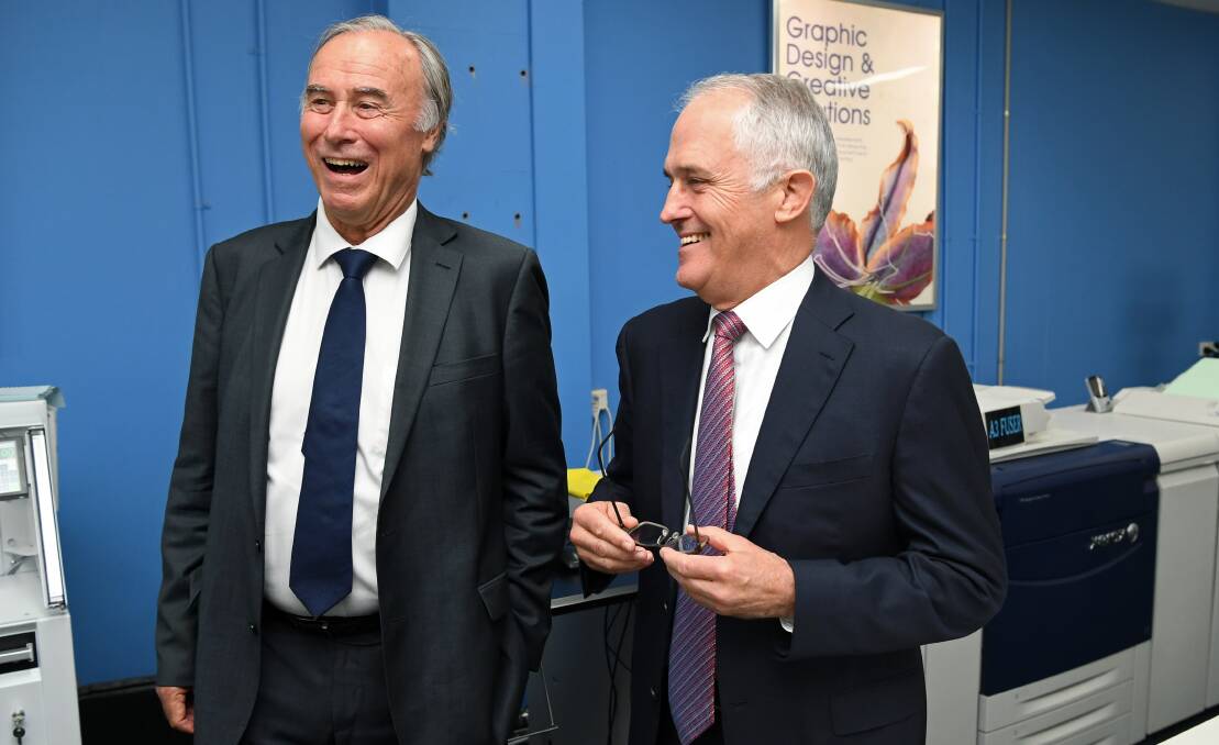 An April 5, 2017 photograph reissued on Saturday, November 11, 2017, of Australian Prime Minister Malcolm Turnbull, and Federal Member for Bennelong, John Alexander (left), talk during a visit to the ColourCorp printing company in Sydney. Mr Alexander has announced his resignation from Parliament because he suspects he holds British citizenship. (AAP Image/Paul Miller)