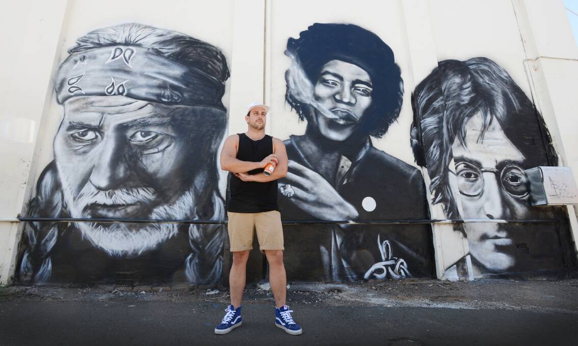 TALKING POINT: Tamworth artist Shane Salvador has transformed a desolate wall in the Brisbane St building housing Keo Design and BWS into an eye-catching mural. Photo: Barry Smith 110315BSD02