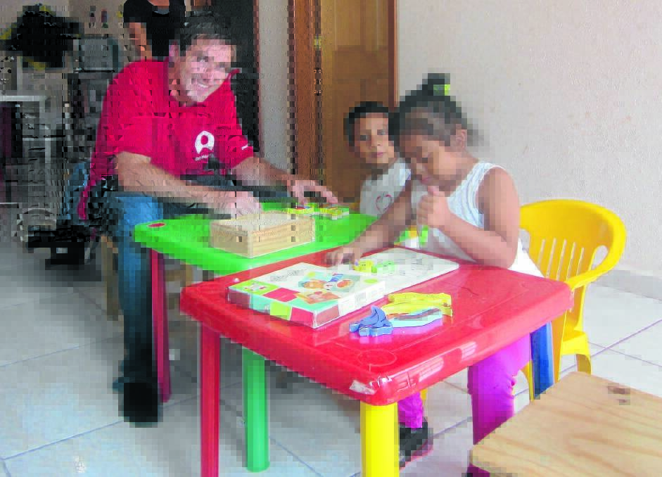GAMES: Paul Moffatt and some students at the special-needs school enjoy some playtime.