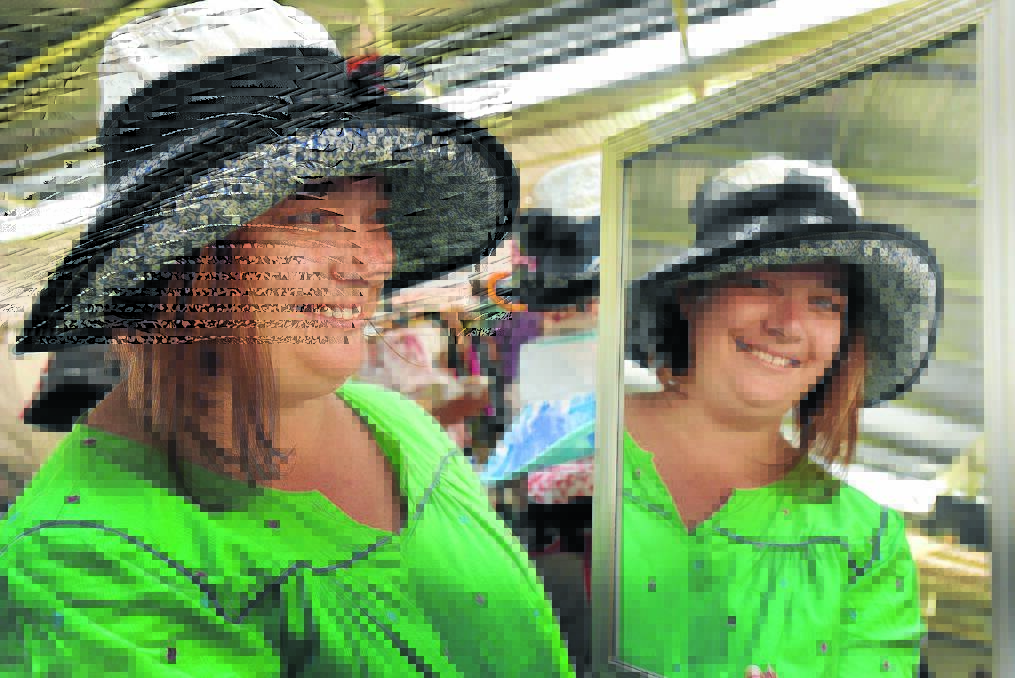 Rachel Mangan checks out the look and fit of a hat at the fair. 221115GOB03