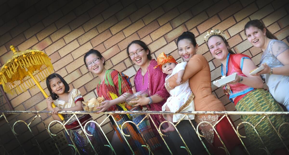 COLOURFUL CELEBRATIONS: Preparations for the multicultural street festival are under way for Adara Serein (6), Ariane Ang, Sara Sarungallo, Wido Triwati, John Tolosa (12 months), Lucy Porter and Brianna Collins who are putting together the Indonesian stall. Photo: Barry Smith 071015BSB04