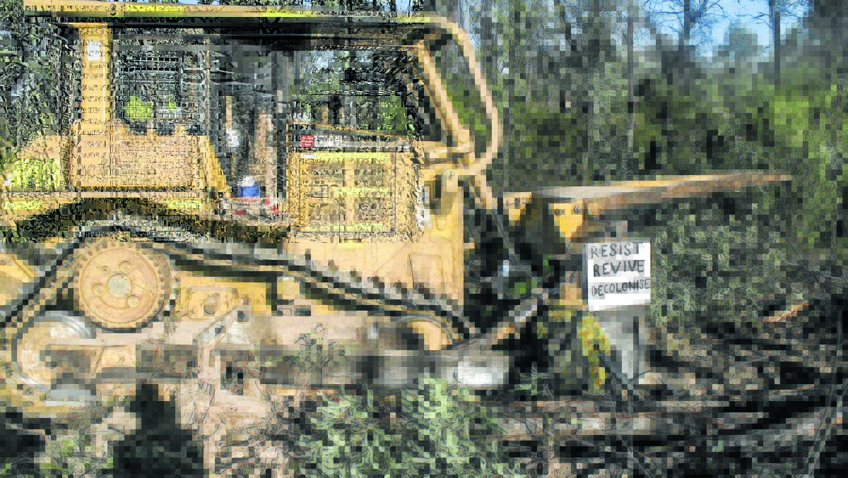 LOCKED-ON: Two women, a farmer and a childcare worker, locked on to a bulldozer clearing in the Leard State Forest on Saturday.