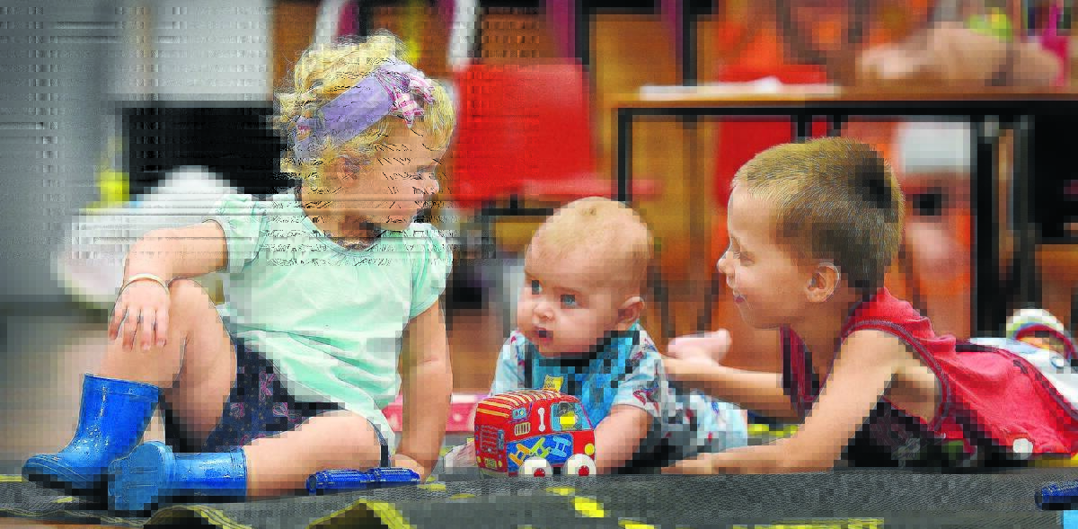 FLOOR PLAY: Five-month-old Tyson Trompa wasn’t left out on his first day at playgroup. He made friends straight away with Lacey Stubbs, 22 months, left, watched over by his big brother, four-year-old Aiden-James (AJ) Trompa. Photo: Gareth Gardner 090216GGA13