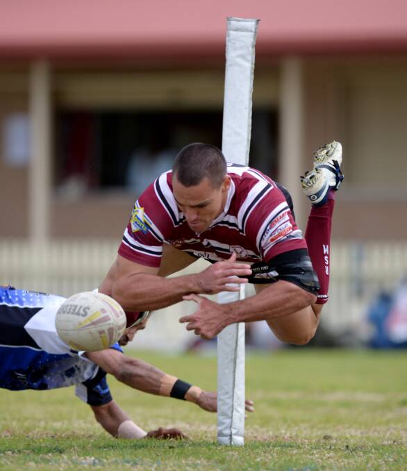 Inverell winger Aaron Quinlan spills a rare missed chance over the line after pressure from Moree's Aaron Gordon in last weeks preliminary final spill over. The Hawks will face the Boomerangs in tomorrows grand final with a big battle in the middle being billed by both sides. Photo: Grant Robertson