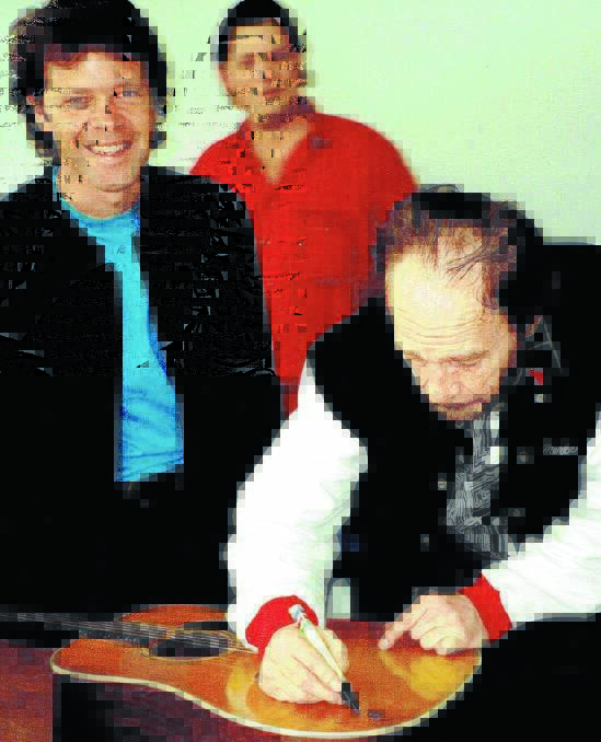 HERO: Merle Haggard signs Troy Cassar-Daley’s guitar in 1996.