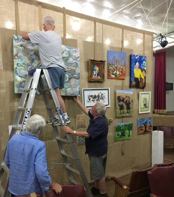 ARTISTS' DELIGHT: Nundle community members helped the CWA set up the art exhibition ready for opening night on Friday. Photo: Supplied