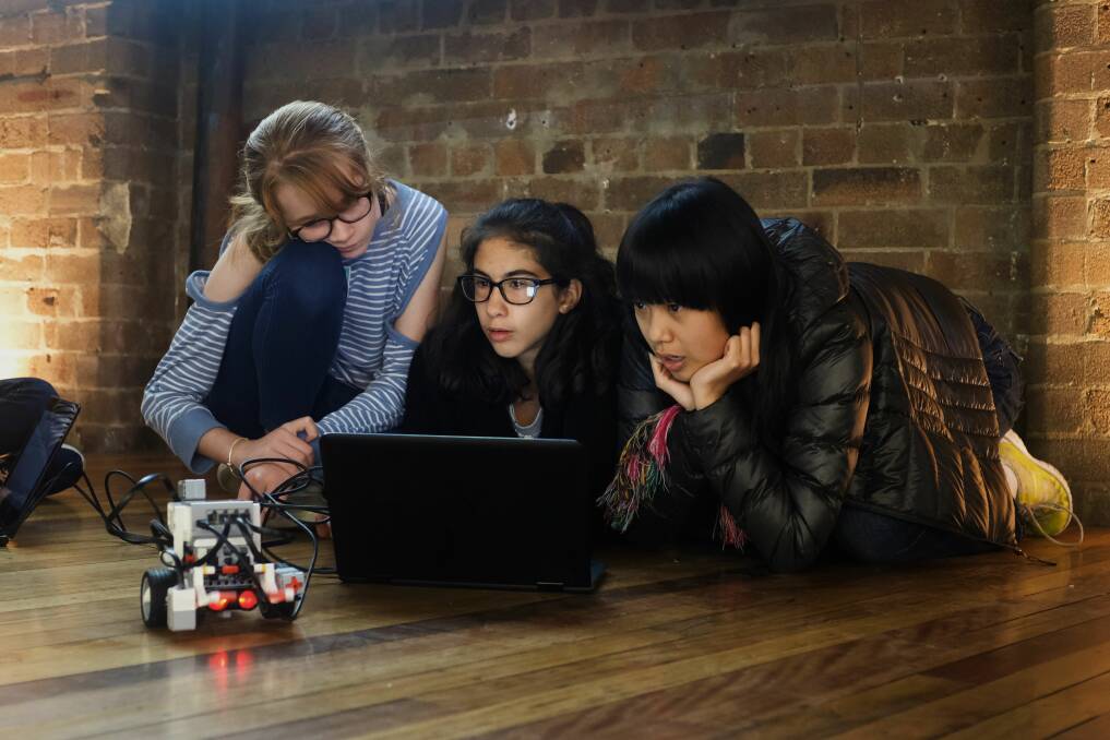 Girls working together to program robotics.