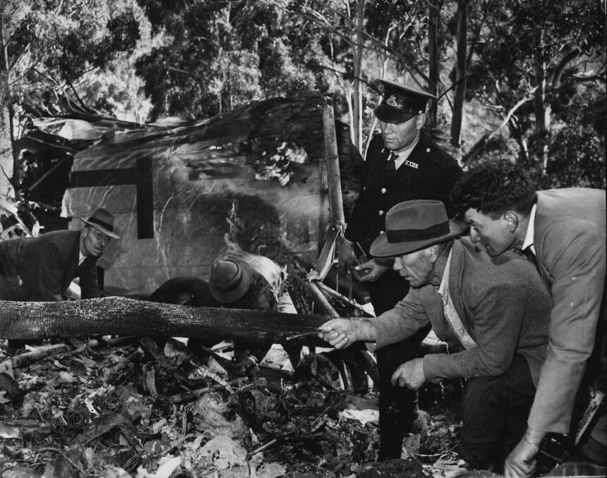 Downed: Inspecting the wreckage of the crashed plane.
