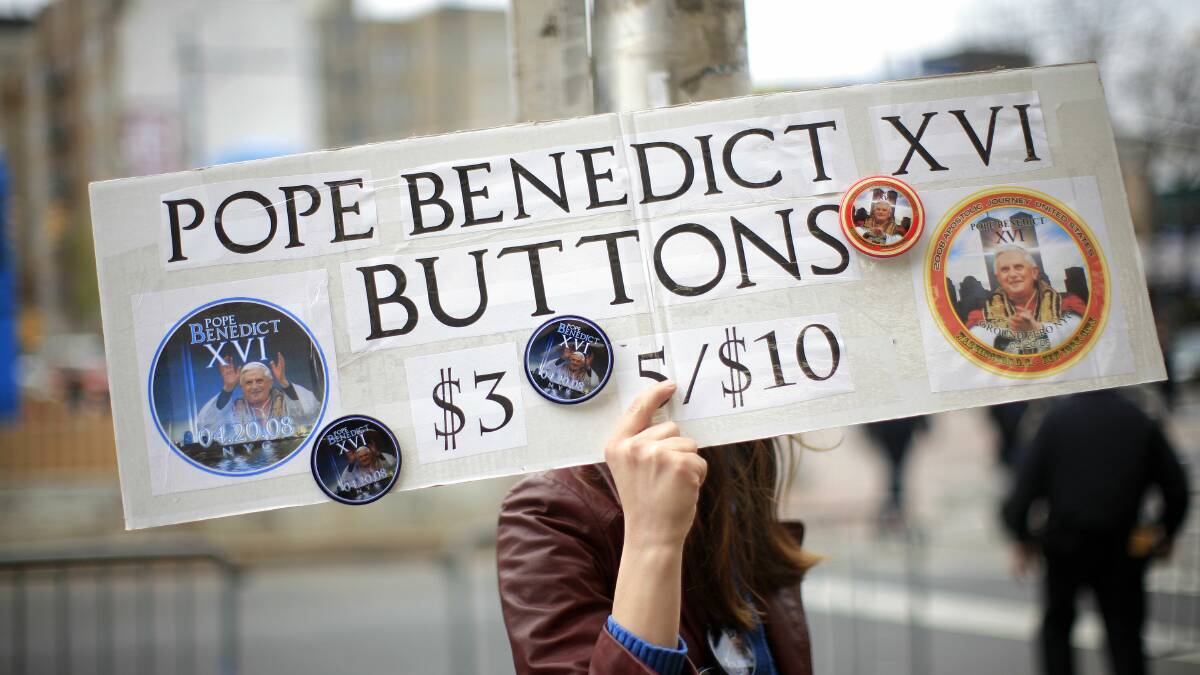 A file picture taken on April 20, 2008 shows a vendor selling buttons while waiting for the mass held by Pope Benedict XVI to begin at the Yankee Stadium  in New York City. Photo: GETTY IMAGES