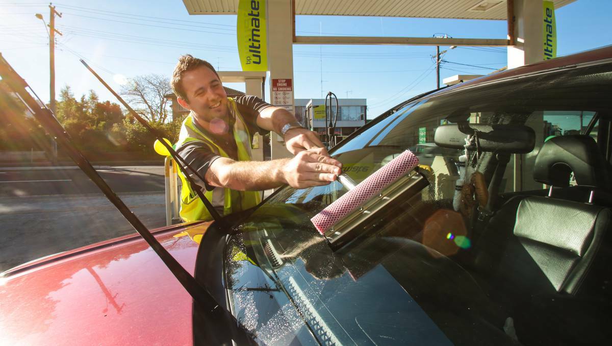 Guy Higgins at the pump of the BP service station at the top of Crown Street, Wollongong, which is offering old-style driveway service. Photo: ADAM McLEAN