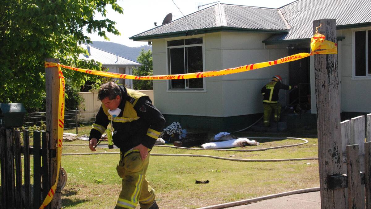 HOUSE FIRE: A Tamworth firefighter leaves the scene of the blaze that could have destroyed a Thompson Cr home yesterday morning. Photo: Kitty Hill 141112KHA01