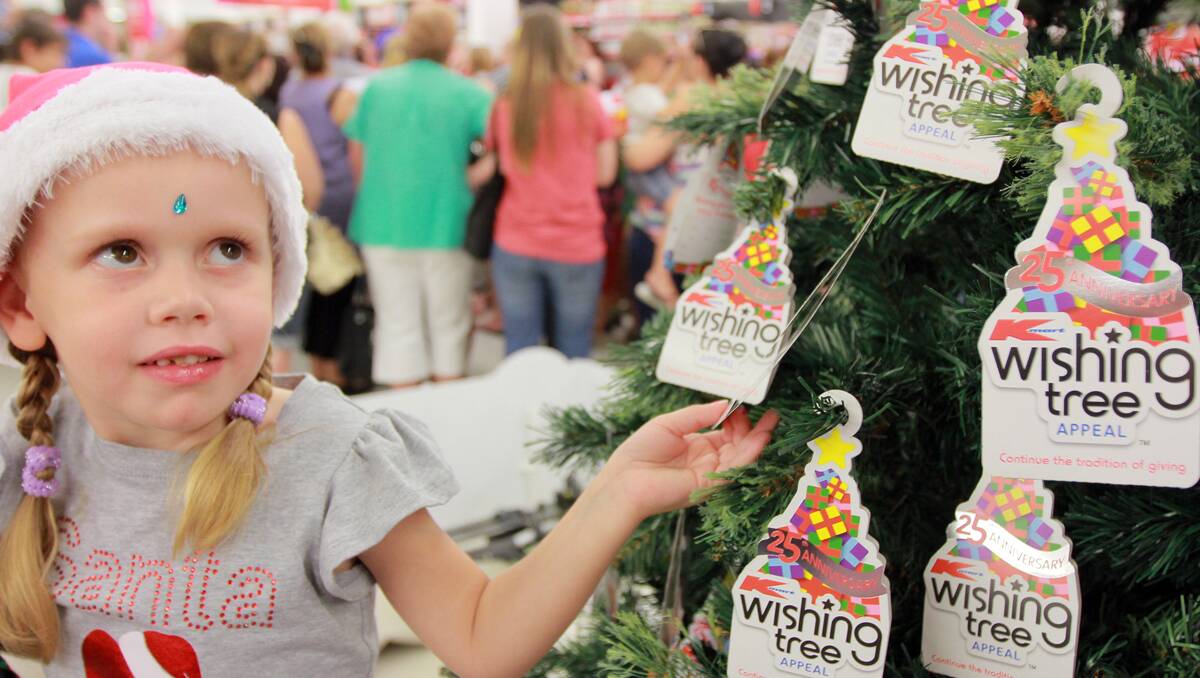 GIVE GENEROUSLY: Four-year-old Mylee Morris from Tamworth with the Kmart Wishing Tree. Photo: Robert Chappel 141112RCC06