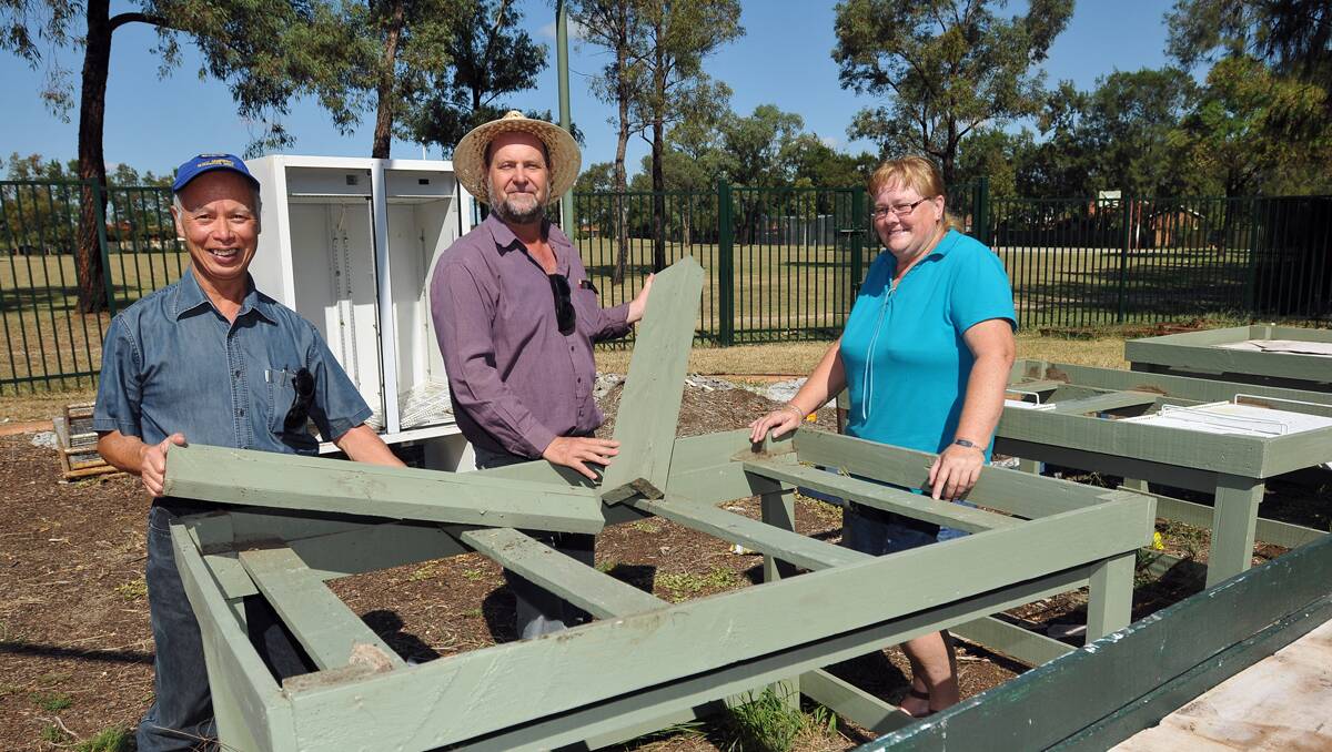 WE'LL BE ENTERING: Tamworth Tidy Towns Committee president Paul Ying, left, with Coledale Community Garden president Paul Moxon and the group's secretary, Cheryl Carpenter, building some portable garden beds. Photo: Geoff O'Neill 270313GOC01