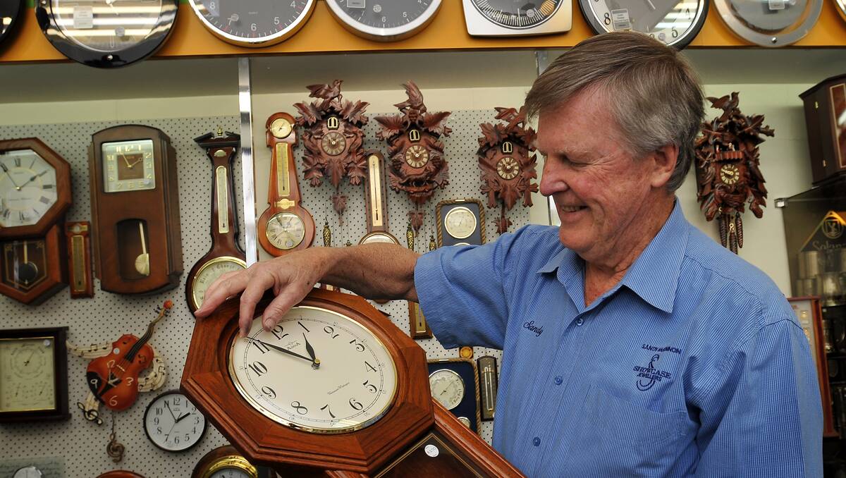 OLD HAND: Sandy McKinnon finishes up winding the clocks forward for another daylight saving year in his Peel St shop. Photo: Geoff O’Neill 041012GOC01