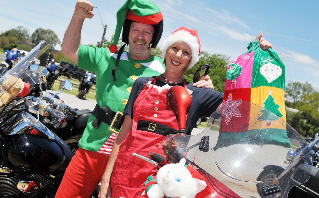 GOOD CAUSE: Dave and Deb McCoy are the very definition of Christmas cheer prior to taking off on the Ulysses Club’s annual toy run. Photo: Geoff O’Neill 071213GOE10