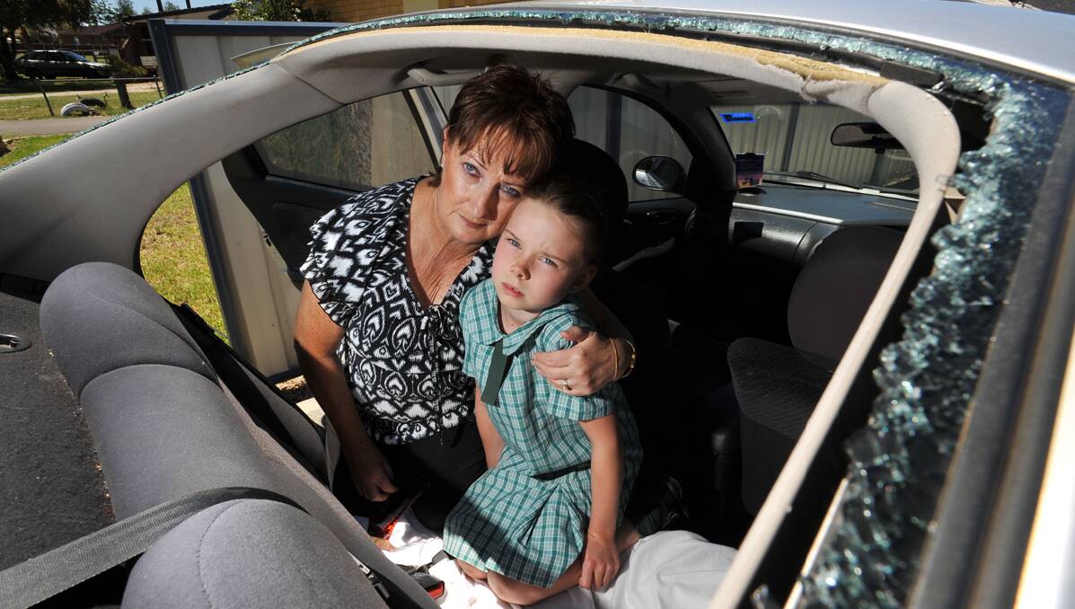 FRIGHTENING: Maxine Solomons with her granddaughter, Jazzmin Herle, 7, in the back of Maxine’s car where a tree branch came crashing through during Monday’s storm. Photo: Barry Smith 041212BSE06